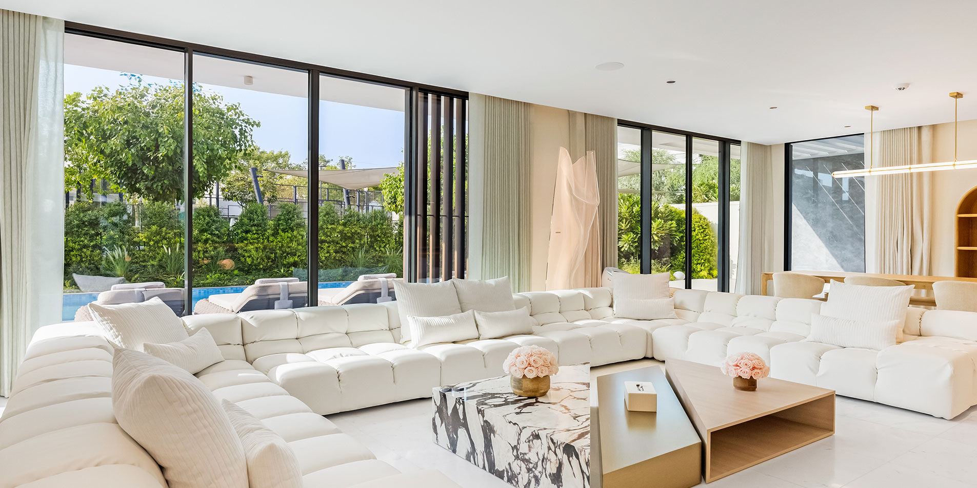 tilal al ghaf poolside living room with white sofas and marble coffee table